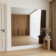 Grijs gekleurde halspiegel aan de muur in entree