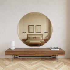 Ronde brons gekleurde spiegel aan de muur in warm interieur