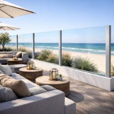 Een glazen windscherm op een strandterras