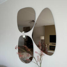 Organische spiegel brons gekleurd in de woonkamer aan de muur