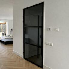 Rookglas in een zwarte deur in de woonkamer