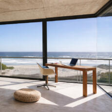 Vloer-tot-plafond ontspiegeld glas in een strandhuis.