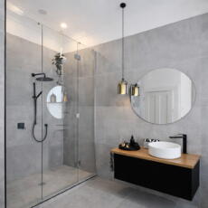 Glazen douchedeur en ronde spiegel in moderne badkamer