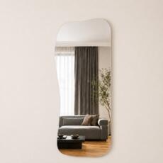 Organische spiegel Demi met asymmetrische vorm en randloos design in een modern interieur.