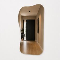 Organische spiegel Demi in brons spiegelglas met asymmetrische vorm en randloos design.