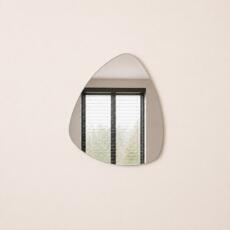 Organische spiegel Nicole met compacte, vloeiende vorm en randloos design.