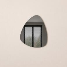Organische spiegel Nicole in grijs spiegelglas met compacte, vloeiende vorm.