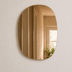 Organische spiegel model 3 brons getint in close-up op lichte muur