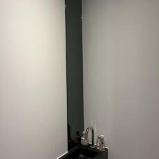 Lange smalle spiegel boven de wasbak. Vastgelijmd in de toiletruimte