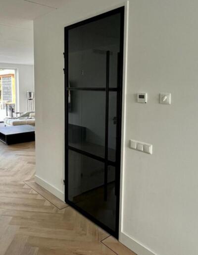 Rookglas in een zwarte deur