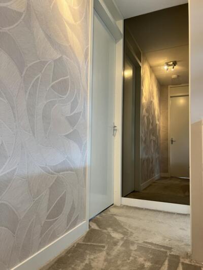 Halspiegel brons gekleurd, aan de muur geplakt