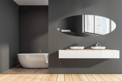 Een verzilverde ovaal spiegel in een badkamer