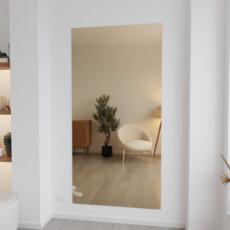 Brons gekleurde plakspiegel aan de muur in modern interieur